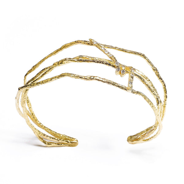 The Under a Tree cuff is a stunning piece that captures the essence of nature's beauty in a statement of elegance and modern style. Crafted from textured 18k yellow gold, this cuff showcases a unique design that exudes both vitality and sophistication. The center element is accented by petite diamonds, adding a bright sparkle that enhances its dynamic appeal. Perfect for those who appreciate fine craftsmanship and distinctive jewelry, the Under a Tree cuff is a must-have accessory.