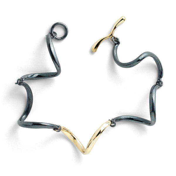 The InsideOut textured links bracelet in blackened sterling silver is adorned with small, shiny 18k yellow gold elements, featuring a delicate diamond. These dangling gold elements add a playful flare to the dark aesthetic of the bracelet, creating an eye-catching contrast and making it a stylish accessory for any occasion.  • Blackened sterling silver, 18k yellow gold, diamonds 0.09 cts