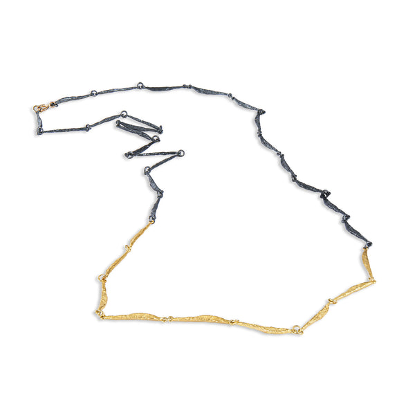 The Spark & Soul necklace features a long and fluid design, combining sterling silver and 18k yellow gold. This piece is an elegant and feminine statement. • Blackened sterling silver, 18k yellow gold