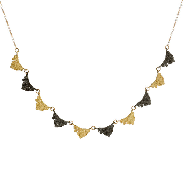 This Svelare necklace showcases a series of textured elements alternating between radiant 18k yellow gold and alluring blackened sterling silver. This harmonious fusion of boldness and refinement epitomizes timeless elegance, making it suitable for both everyday wear and special occasions alike. • Length: 18"