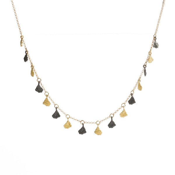 This Svelare necklace boasts a series of dangling textured elements, alternating between radiant 18k yellow gold and alluring blackened sterling silver. This harmonious fusion of boldness and refinement epitomizes timeless elegance, rendering it suitable for both everyday wear and special occasions alike. • 18k yellow gold, blackened sterling silver • Length: 20 inches