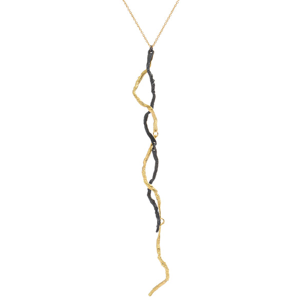 The Mystic Black & Gold Pendant by Emanuela Duca - The Mystic pendant is crafted in 18k yellow gold and blackened sterling silver. Its intricate texture and contrasting metals create a captivating allure, accentuated by a long, sensual pendant delicately held by a thin chain. It's more than jewelry; it's a wearable sculpture, a testament to elegance and artistry.