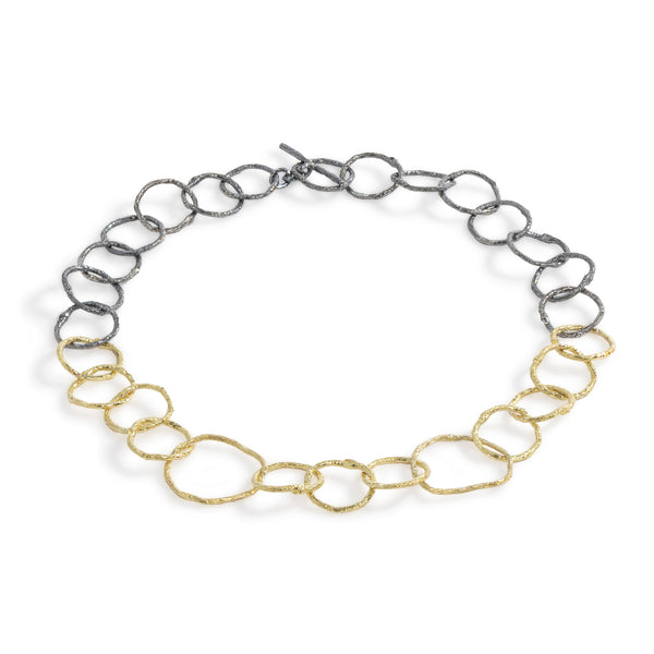 The Mystic Links Necklace by Emanuela Duca - -The Mystic Links Necklace, a fusion of 18k yellow gold and blackened sterling silver. Its large, textured links and contrasting metals exude a captivating allure. Standing proudly on its own, this necklace embodies sophistication with a touch of romantic flair.