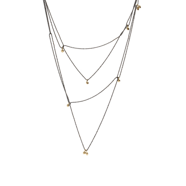 The Mystic Necklace by Emanuela Duca - A delicate fusion of blackened sterling silver and gleaming gold nuggets. Its textured thin chain moves softly, creating ever-changing combinations. Proudly part of the Mystic collection, it embodies constant transformation and timeless allure. Wear it long, double it up, or hook it in various places for distinct styles. Its adaptability adds a touch of intrigue to any look, making it a must-have accessory.