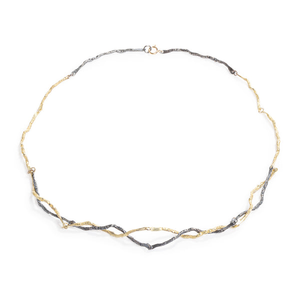 Raw You Intertwined Black & Gold Necklace by Emanuela Duca - This captivating necklace is a harmonious blend of 18k yellow gold and blackened sterling silver, intricately intertwined for a modern yet earthy allure. This piece epitomizes contemporary elegance with its textured elements, offering a distinctive statement of style. Length: 17 inches.