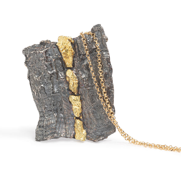 Raw You Black & Gold Pendant by Emanuela Duca - This is wearable art, a textured pendant crafted from blackened sterling silver, accented with 18k yellow gold elements. With an earthy yet contemporary aesthetic, this piece is more than just jewelry—it's a sculptural masterpiece to adorn your neckline with style and sophistication. Height: 2 inches. Chain length: 19 inches. One of a kind.