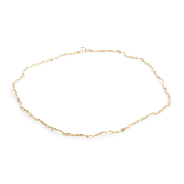 Good Vibes Gold Necklace by Emanuela Duca - Crafted as an earthy yet elegant alternative to the traditional gold chain, this piece boasts textured 18K yellow gold elements that seamlessly interconnect, forming a harmonious ensemble of beauty and sophistication. Whether worn as a statement piece or as a subtle accent, this necklace embodies understated luxury with its contemporary design and timeless appeal.