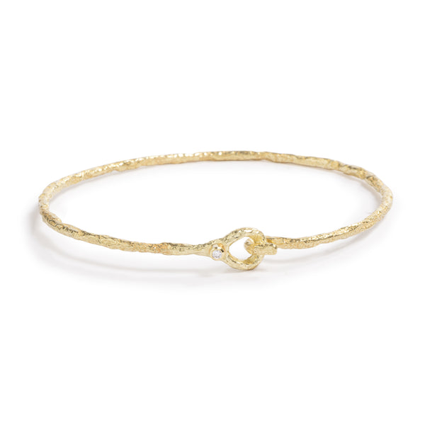 Good Vibes Gold Bracelet by Emanuela Duca - A thin and earthy bracelet crafted from textured 18K yellow gold, adorned with a petite 2mm diamond. Its delicate design exudes understated sophistication, while the secure closure ensures both style and comfort.