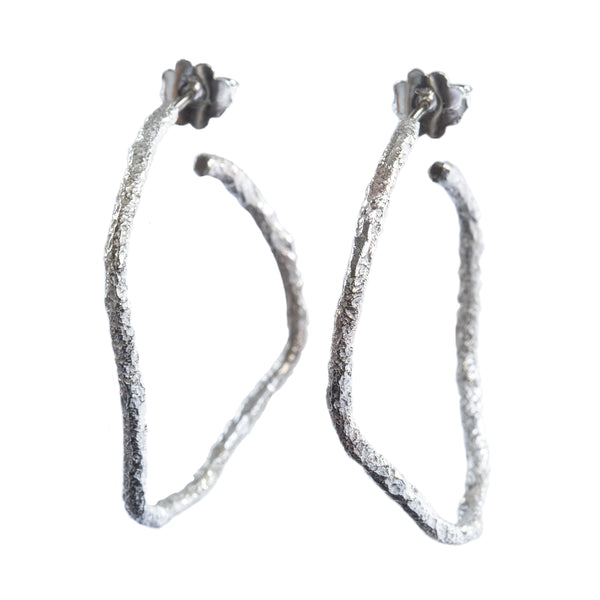 The Spark & Soul hoop earrings in sterling silver showcase simplicity with a touch of earthy and contemporary flair. • Sterling silver • Diameter: 1.5"