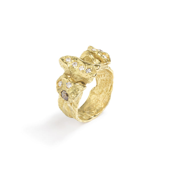 Raw You Diamonds Gold Ring by Emanuela Duca - Introducing an 18k yellow gold ring with captivating texture and an array of diamonds: 8 white diamonds (2mm) and 2 cognac diamonds (3mm). With its fashionable edge and primal essence, this ring strikes the perfect balance of modernity and raw allure, making it a must-have for any bold and sophisticated ensemble.