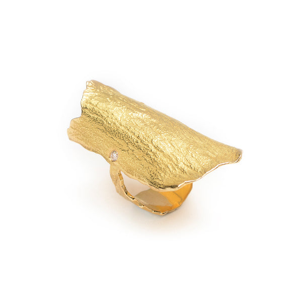 The Under a Tree ring is a stunning piece that embodies the elegance and vitality of nature. Crafted from 18k yellow gold, the ring features a beautifully textured surface that evokes the energy and beauty of a majestic tree. An off-center, petite diamond adds a touch of sparkle, making this ring a perfect blend of elegance and edginess. Ideal for those who love to make a bold statement with their jewelry, the Under a Tree ring is both unique and timeless. • 18k yellow gold, diamond 0.05 cts