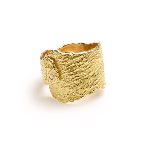 The Under a Tree ring is a beautiful piece that embodies the elegance and vitality of nature. Crafted from 18k yellow gold, the ring features a beautifully textured surface that evokes the energy and beauty of a majestic tree. An off-center, petite diamond adds a touch of sparkle, making this ring a perfect blend of elegance and edginess. Ideal for those who love to make a statement with their jewelry, the Under a Tree ring is both unique and timeless. • 18k yellow gold, diamond 0.03 cts