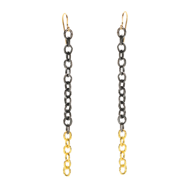 The Under a Tree earrings are designed to make a bold statement with a touch of edge and personality. These striking earrings feature a handmade chain of textured 18k yellow gold, beautifully contrasted by a chain crafted from blackened sterling silver. The fluid, elongated design creates a fashion-forward look that is both dynamic and sophisticated. Perfect for those who love to stand out, the Under a Tree earrings are a unique blend of elegance and modern style.