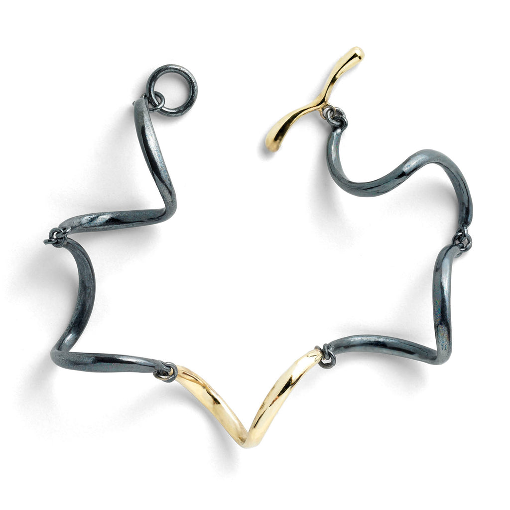 The InsideOut textured links bracelet in blackened sterling silver is adorned with small, shiny 18k yellow gold elements, featuring a delicate diamond. These dangling gold elements add a playful flare to the dark aesthetic of the bracelet, creating an eye-catching contrast and making it a stylish accessory for any occasion.  • Blackened sterling silver, 18k yellow gold, diamonds 0.09 cts