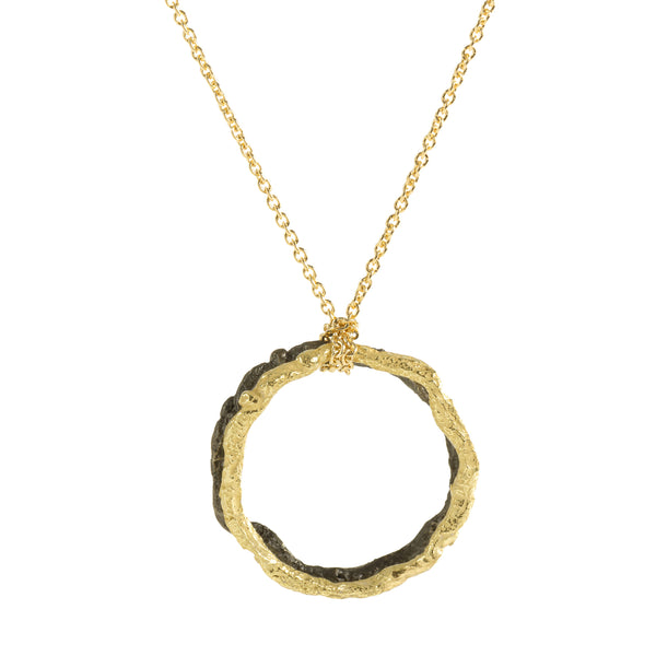 The November's Moon necklace, featuring a blend of 18k yellow gold and blackened sterling silver, strikes a perfect harmony between simplicity and edgy contemporary style. Suspended from a delicate 18-inch gold chain is a pendant comprising a textured circle of gold contrasted with one of blackened sterling silver.  • Chain length: 18"; Pendant: 1"