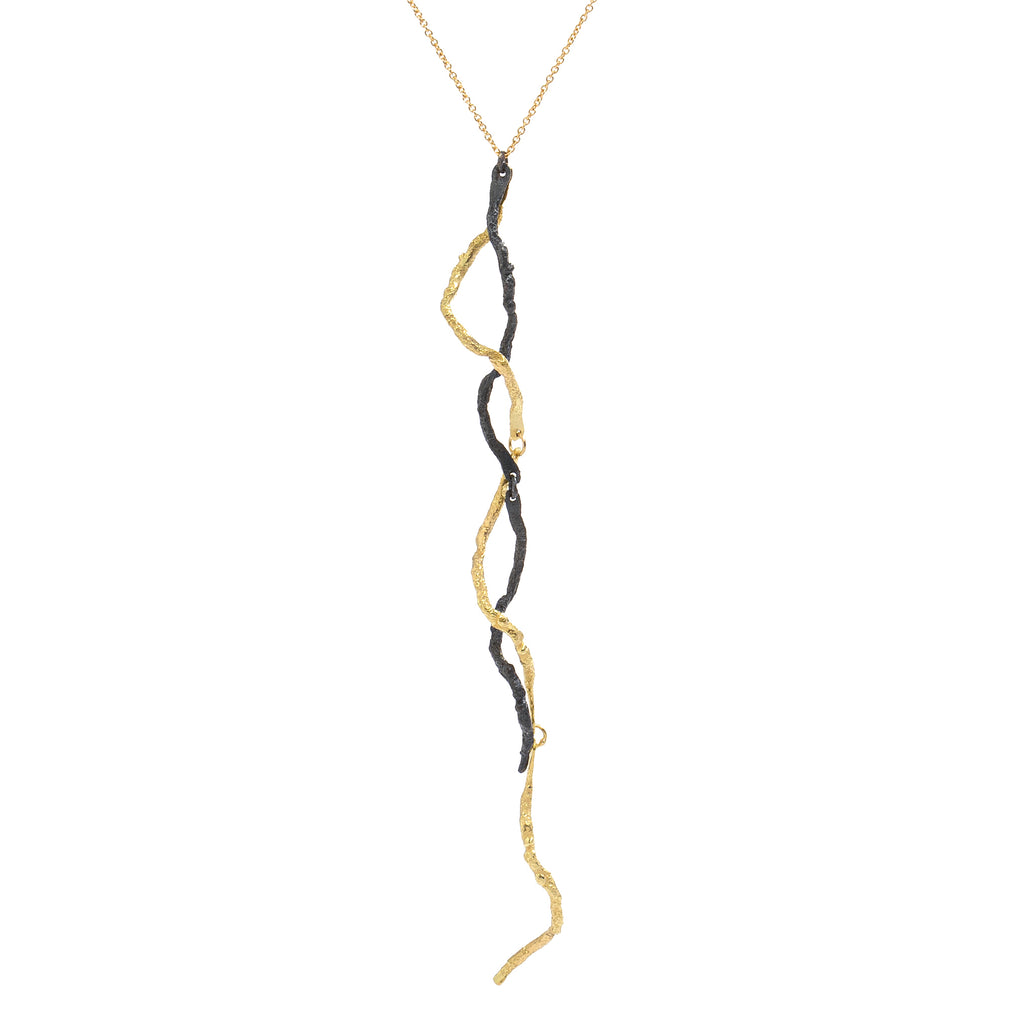 The Mystic Black & Gold Pendant  by Emanuela Duca - The Mystic pendant is crafted in 18k yellow gold and blackened sterling silver. Its intricate texture and contrasting metals create a captivating allure, accentuated by a long, sensual pendant delicately held by a thin chain. It's more than jewelry; it's a wearable sculpture, a testament to elegance and artistry. 