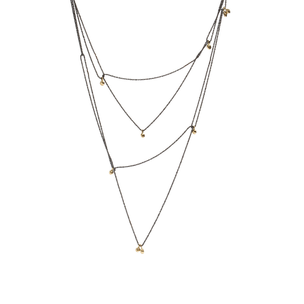 The Mystic Necklace by Emanuela Duca - A delicate fusion of blackened sterling silver and gleaming gold nuggets. Its textured thin chain moves softly, creating ever-changing combinations. Proudly part of the Mystic collection, it embodies constant transformation and timeless allure. Wear it long, double it up, or hook it in various places for distinct styles. Its adaptability adds a touch of intrigue to any look, making it a must-have accessory. 