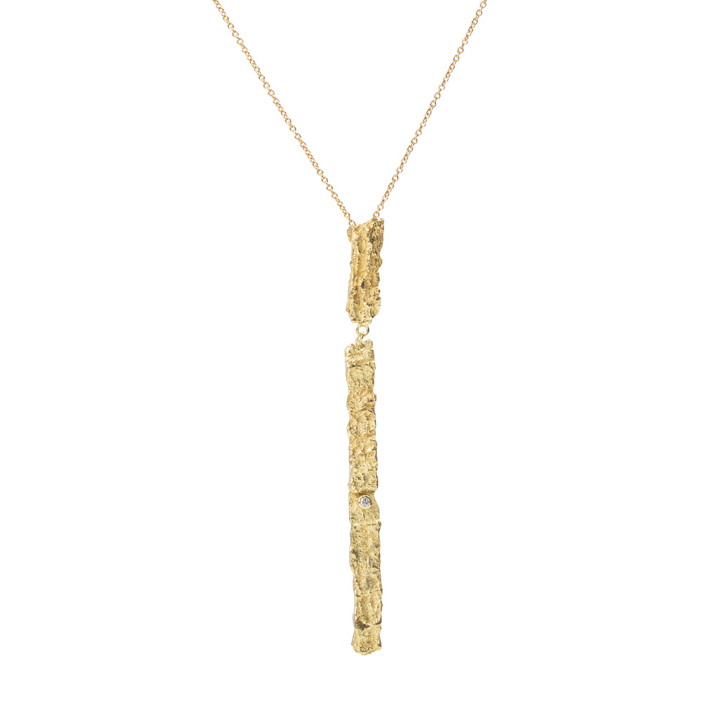 Raw You Long Gold Necklace by Emanuela Duca - The Raw You Collection's pendant necklace. Adorned with a petite diamond, its long textured pendant exudes sophistication and allure. A symbol of individuality and femininity, this design speaks volumes with its understated charm. Height: 3 inches.