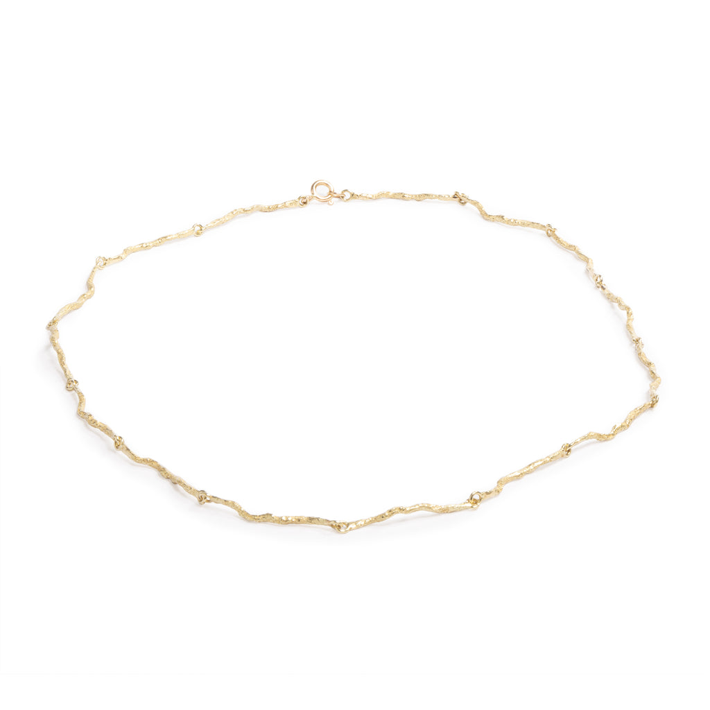 Good Vibes Gold Necklace by Emanuela  Duca - Crafted as an earthy yet elegant alternative to the traditional gold chain, this piece boasts textured 18K yellow gold elements that seamlessly interconnect, forming a harmonious ensemble of beauty and sophistication. Whether worn as a statement piece or as a subtle accent, this necklace embodies understated luxury with its contemporary design and timeless appeal.