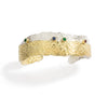 Good Vibes Gold & Silver Cuff by Emanuela Duca - A cuff bracelet adorned with textured 18K yellow gold and sterling silver layers. Accented by vibrant touches of ruby, emerald, and blue sapphires, this piece exudes elegance and sophistication. The overlapping layers create a captivating visual contrast, making it a statement accessory for any occasion.