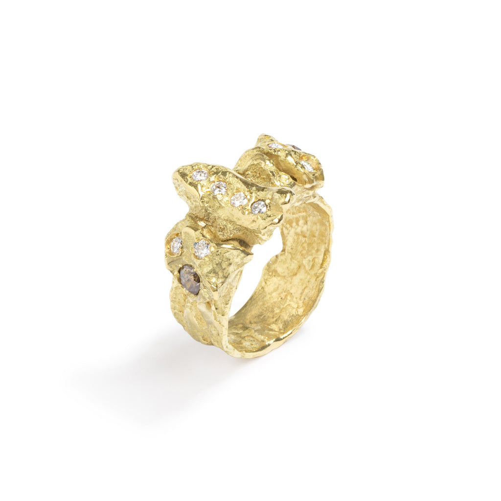 Raw You Diamonds Gold Ring by Emanuela Duca - Introducing an 18k yellow gold ring with captivating texture and an array of diamonds: 8 white diamonds (2mm) and 2 cognac diamonds (3mm). With its fashionable edge and primal essence, this ring strikes the perfect balance of modernity and raw allure, making it a must-have for any bold and sophisticated ensemble.