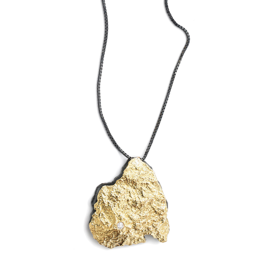 The Burst pendant presents a dynamic composition, featuring a textured 18k yellow gold piece at the forefront adorned with a delicate diamond accent. Its reverse side boasts a contrasting blackened sterling silver element, all suspended from a sleek blackened sterling silver chain, creating a captivating and versatile piece.  • 18k yellow gold, blackened sterling silver, diamond 0.074 cts  • Chain length: 18"&nbsp;