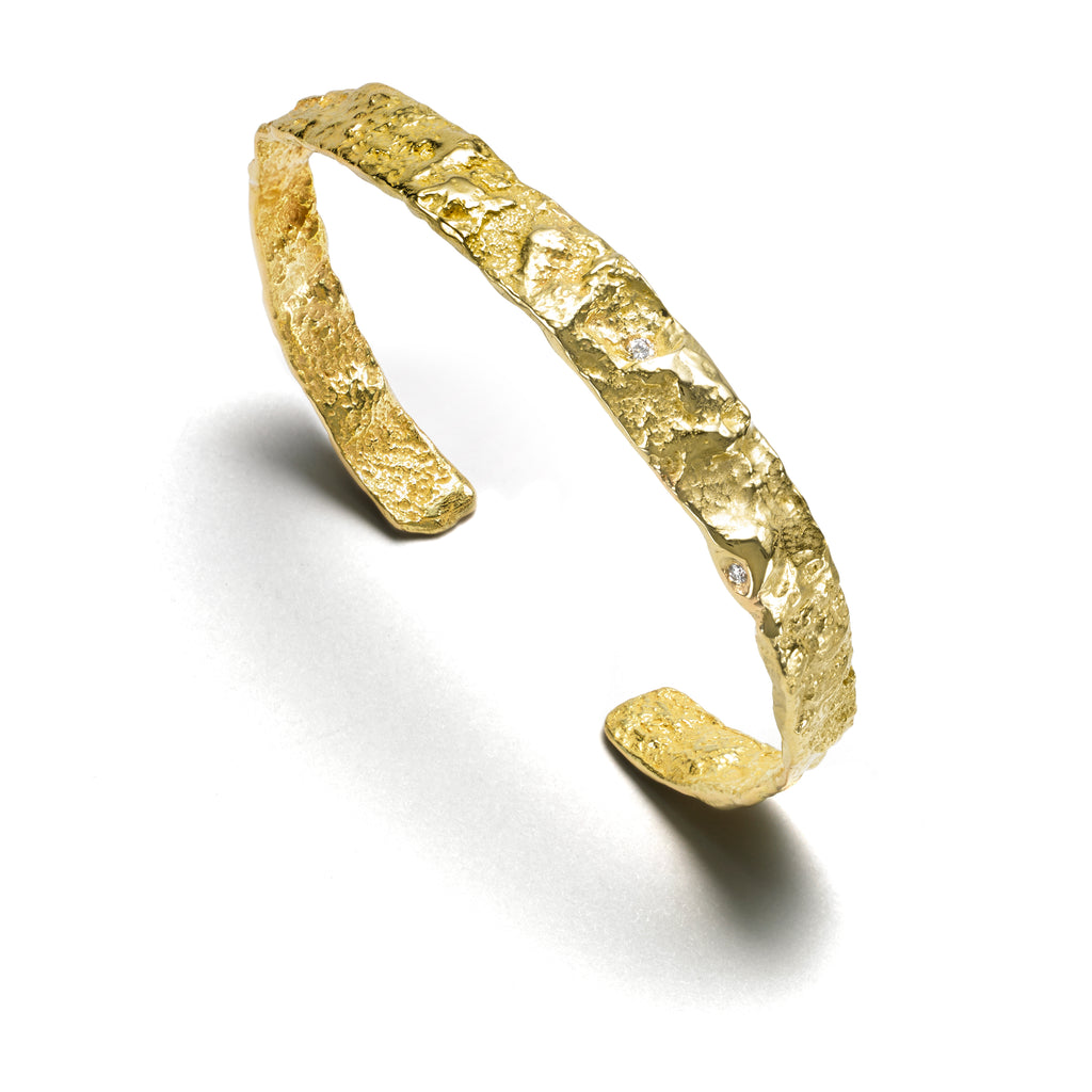 The Burst thin cuff in 18k yellow gold boasts a robust textured surface, delicately accented with small diamonds. Ideal for daily wear, this design exudes timeless elegance and sophistication.  • 18k yellow gold, diamonds 0.04 cts