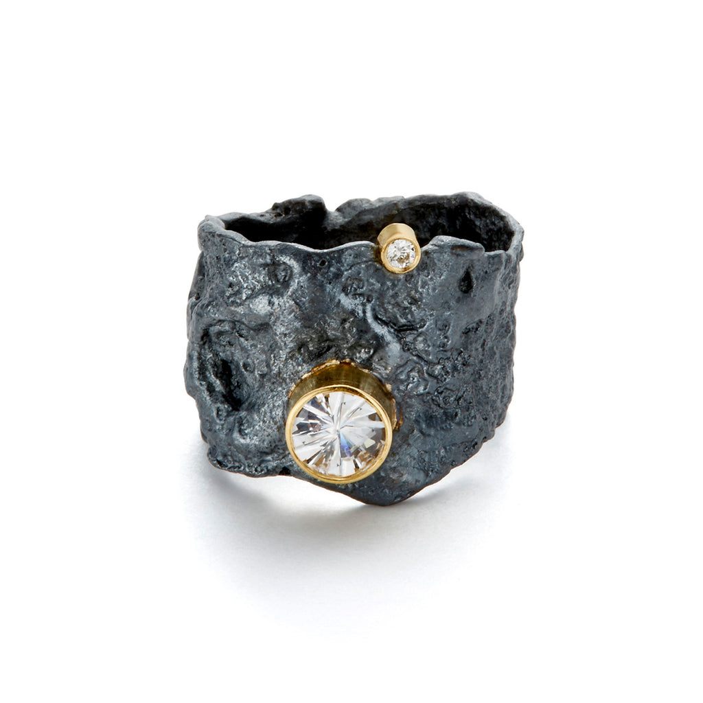 The Floating In The Dark ring indeed sounds captivating. This piece combines the modern elegance of blackened sterling silver with the timeless of 18k yellow gold, creating a striking contrast. The addition of a white sapphire and a diamond not only adds sparkle but also introduces elements of classic sophistication and contemporary style.