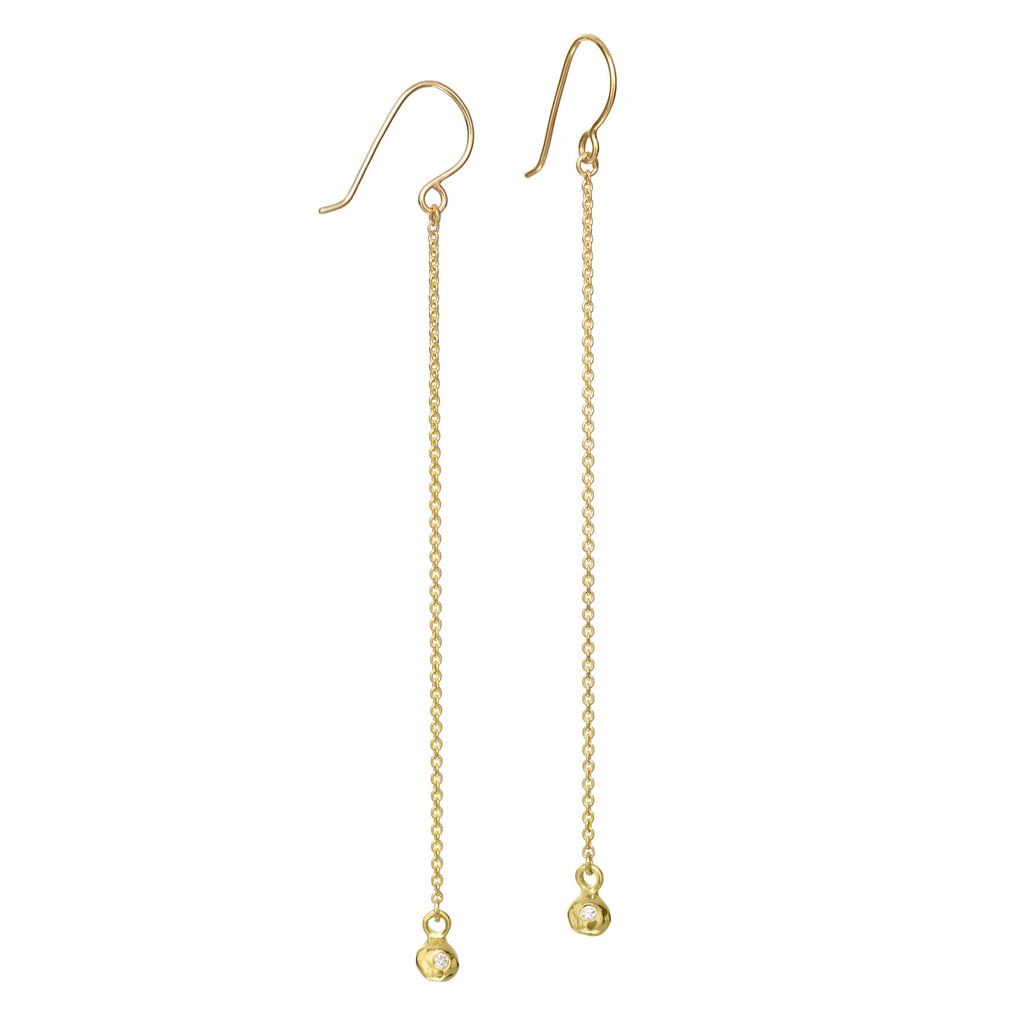 The InsideOut earrings in 18k yellow gold feature a long, thin chain accented by a gold element with a small diamond at the bottom. This design offers a delicate yet luxurious touch, adding subtle elegance to any look.  • 18k yellow gold, diamonds 0.03cts  • Length: 3.5"